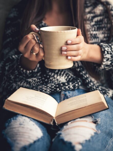 Woman reading book with a coffee cup